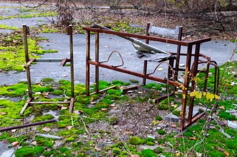 Rusty metal frame of table and chair in schoolyard in Pripyat in alienation zone Stock-Fotos