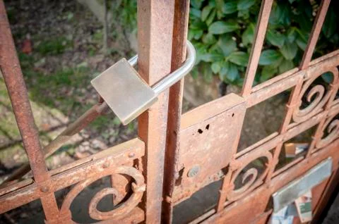 Rusty metal gate closed with padlock .. Stock Photos