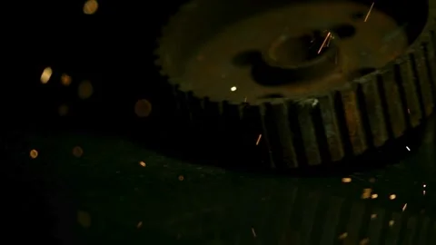 Rusty metal gears on dark surface with flying sparks Stock Footage 327577415