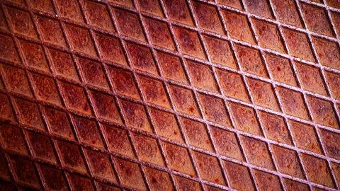 Rusty metal grid pattern with a textured, grainy surface in warm shades of .. Illustrazione stock