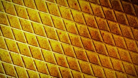 Rusty metal grid pattern with vibrant yellow and orange hues, creating a bo.. Illustrazione stock