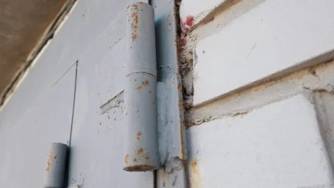 Rusty Metal Hinge On Heavy Grey Door Attached To White Painted Brick Wall Stock Footage 330740599