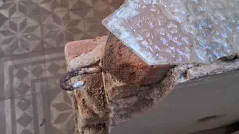 Rusty metal hook embedded in crumbling brick motion video footage Stock Footage 337897061