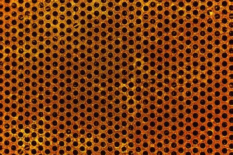 A rusty metal lattice of rectangular shape with a lot of round hole holes on a Stock Photos