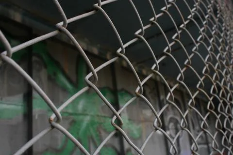 Rusty metal mesh close-up on the background of painted walls Stock Photos