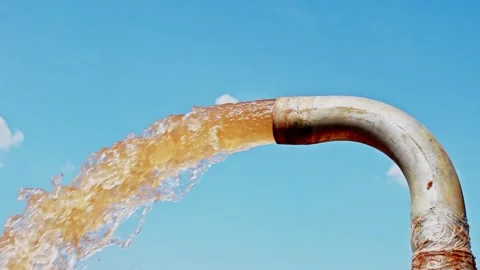 A rusty metal pipe gushes a powerful stream of discolored, brownish water a.. Stock Footage 341354792