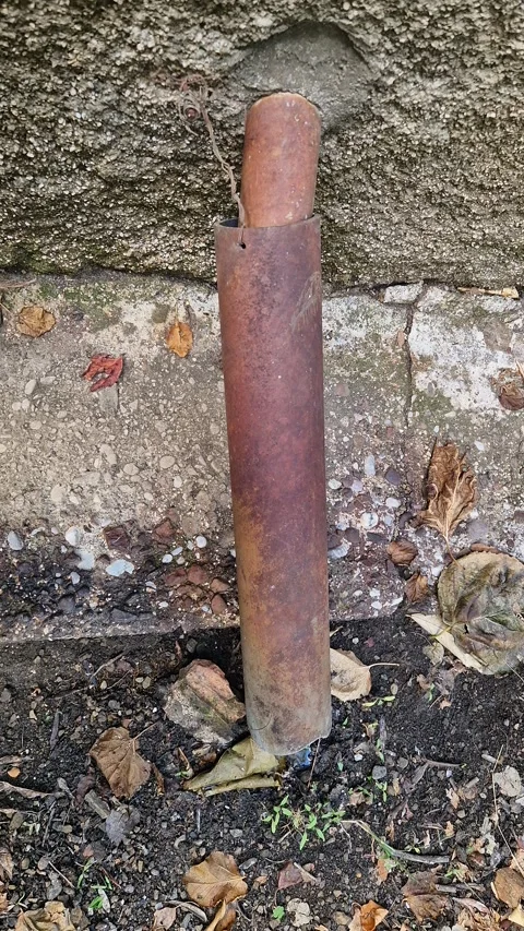 Rusty Metal Pipe by Wall with Concrete and Dry Leaves Stock Footage 318074807