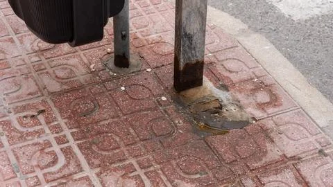 Rusty Metal Pole Base Fixed to Sidewalk Pavement Close Up 스톡 사진