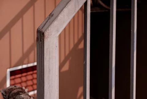 Rusty Metal Railing Casting Shadows on a Peach-Colored Wall Stock Photos