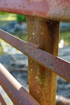 Rusty metal railing with weathered surface near water in a sunny park setti.. 写真素材