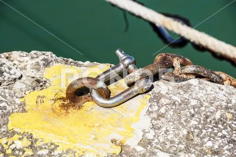 Rusty metal shackle on a mooring rope at pier Stock Photos