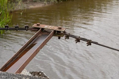 Rusty metal sluice gate in a river. Old industrial water control mechanism .. Фото