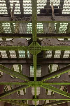 Rusty metal structure with moss growing on beams under an old bridge in an .. Stockfoto's