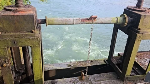 Rusty metal structure over a river with turbulent blue-green Stock-Footage 317778256