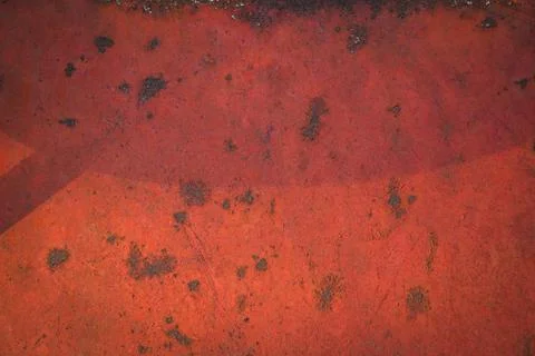 Rusty metal surface covered with red paint with spots. Stock Photos