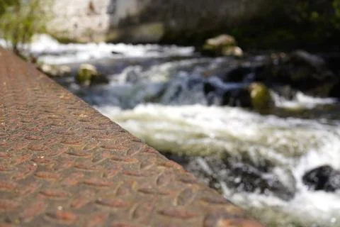 Rusty metal surface with river flow in background, shallow depth outdoor te.. Stock Photos