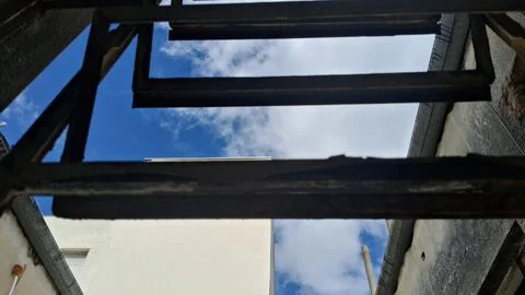 Rusty metal window frame looking out at bright blue sky Stock-Fotos
