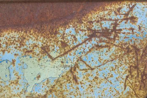 Rusty metallic textured background with remnants of blue paint. Stock Photos
