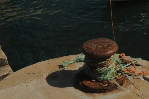 Rusty Mooring Post with Tangled Ropes by Dark Water Stock Photos