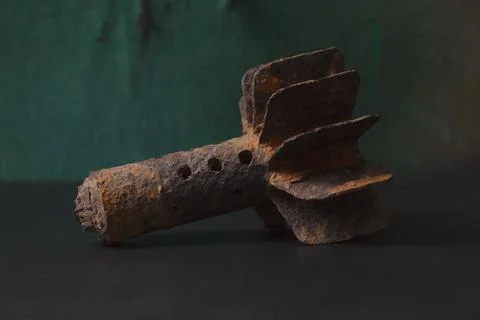 Rusty mortar shell against dark background. Stock Photos