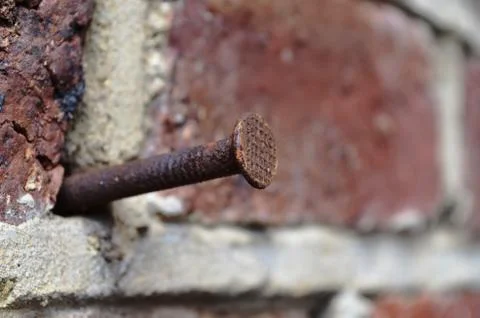 Rusty nail in a Brick wall Stock Photos
