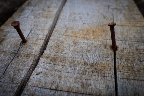 Rusty nails embedded in the surface of wooden planks Stock Photos