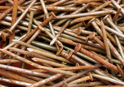 Rusty nails spilled on the worktop. Foto stock