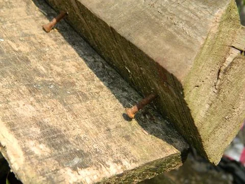 Rusty nails stuck in weathered and bad wood Stock Photos
