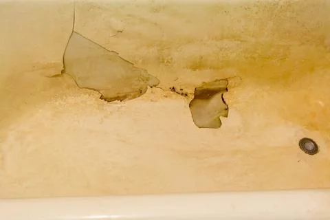 Rusty old bath with peeling enamel. Repair is required. Stock Photos