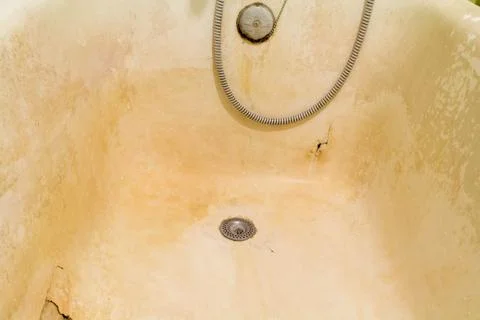 Rusty old bath with peeling enamel. Repair is required. Stock Photos
