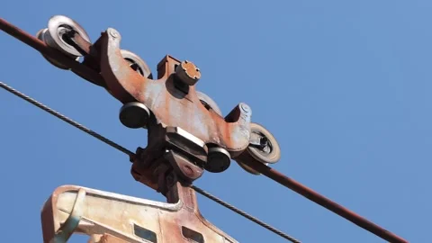 Rusty old cable car mechanism moving on steel rope Stock Footage 345927042