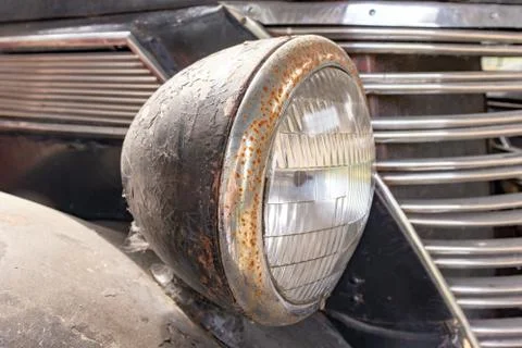 A rusty old car front headlight close up Stock Photos