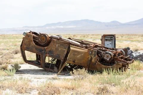 Rusty old car upside down dumped in the desert Stock Photos