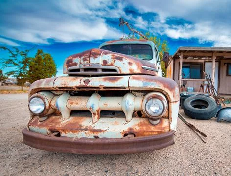 Rusty old cars under a blue sky. Old vintage vehicles in the countryside Stock Photos