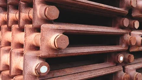 Rusty old cast-iron radiators lie in stack. industrial texture highlights sig Photos