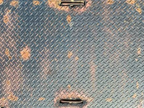 Rusty old diamond plate pattern iron steel metal storm drain door Stock Photos