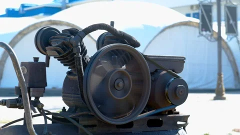 A rusty old engine runs against the backdrop of dome structures Stock Footage 291100732