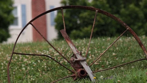 Rusty old farming wheel close up on grass Stock Footage 92846454