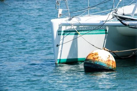 Rusty old float by the bow of an anchored boat Stock Photos
