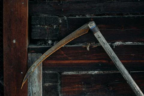A rusty old metal braid hangs on a wooden wall Stock Photos
