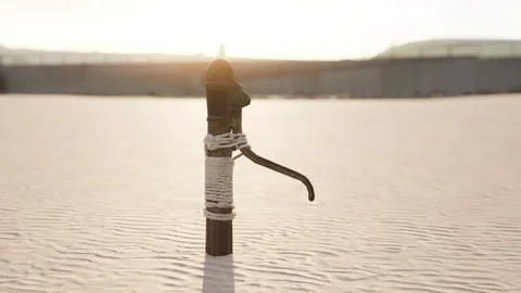Rusty old metal water pump on sand beach Stock Footage 232398820