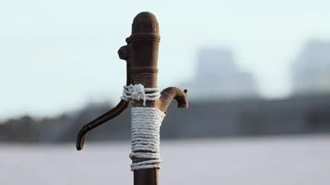 Rusty old metal water pump on sand beach Stock Footage 233517832