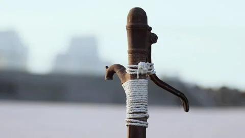 Rusty old metal water pump on sand beach Stock Footage 235310221