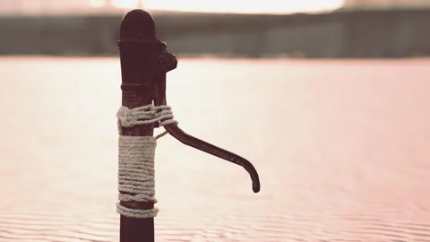 Rusty old metal water pump on sand beach Stock Footage 235975697