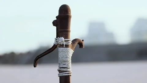 Rusty old metal water pump on sand beach Stock Footage 236835200
