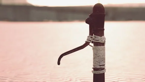Rusty old metal water pump on sand beach Stock Footage 252193108