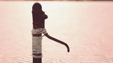 Rusty old metal water pump on sand beach Stock Illustration