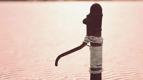 Rusty old metal water pump on sand beach Stock Illustration