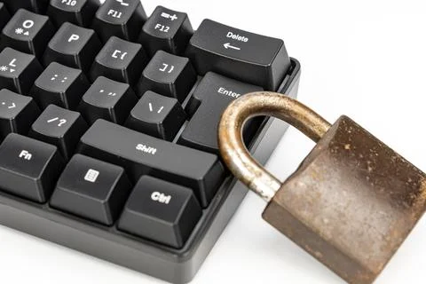 Rusty old padlock resting on computer keyboard symbolizing cyber security Stock Photos