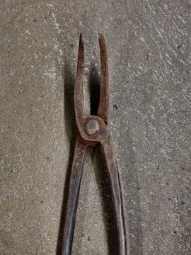 Rusty old pliers resting on rough concrete surface with textured patina and.. Stock Photos